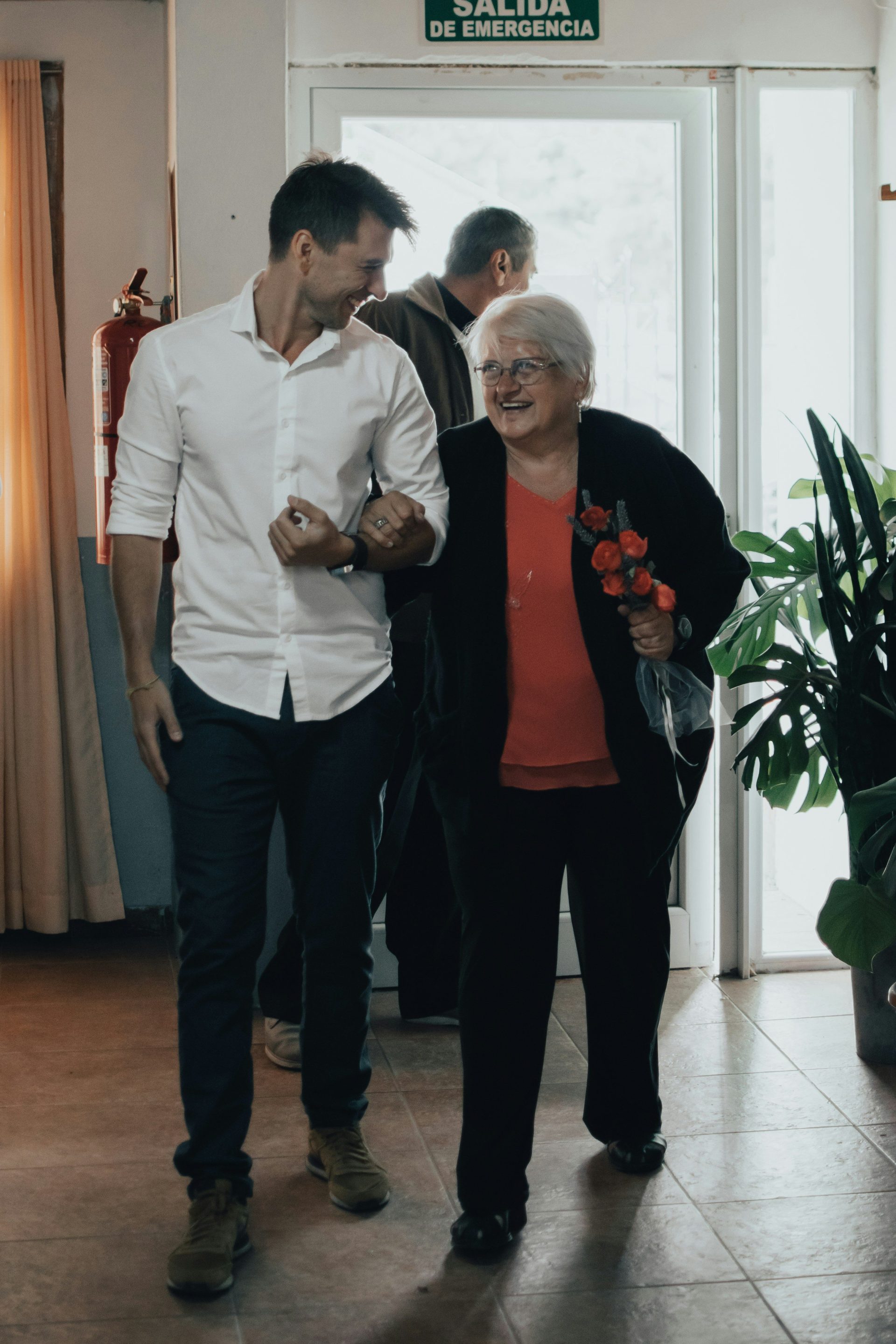 man in white dress shirt standing beside woman in red long sleeve shirt